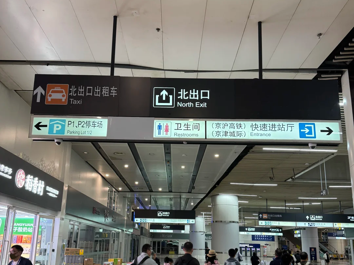 Bilingual exit signs inside a Chinese high-speed railway station