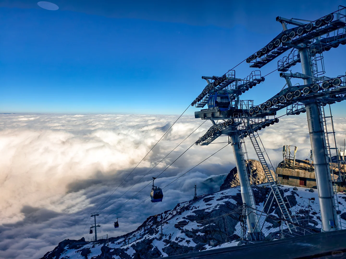 Cable car and cloud-covered snow mountains at Yulong Snow Mountain