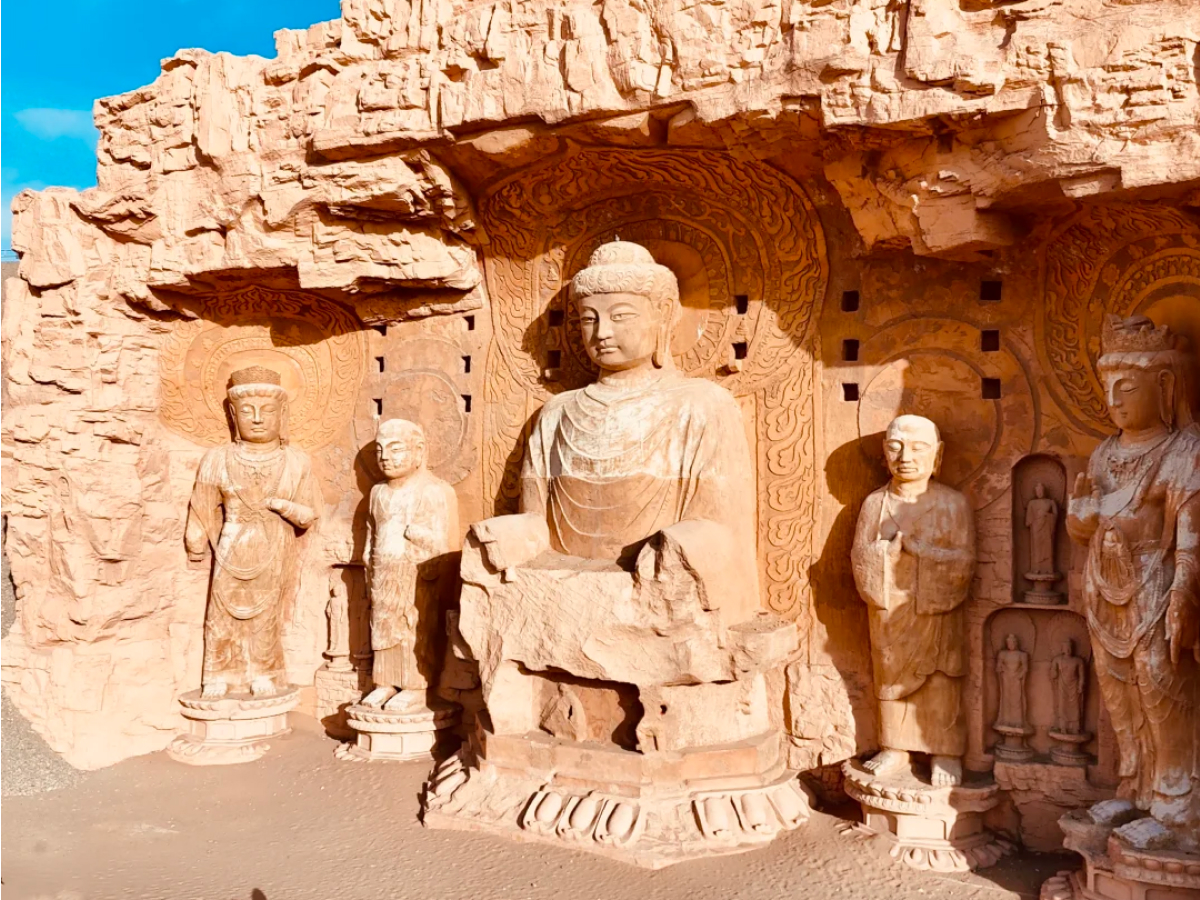 Buddha statues lined along a Dunhuang grotto cliff