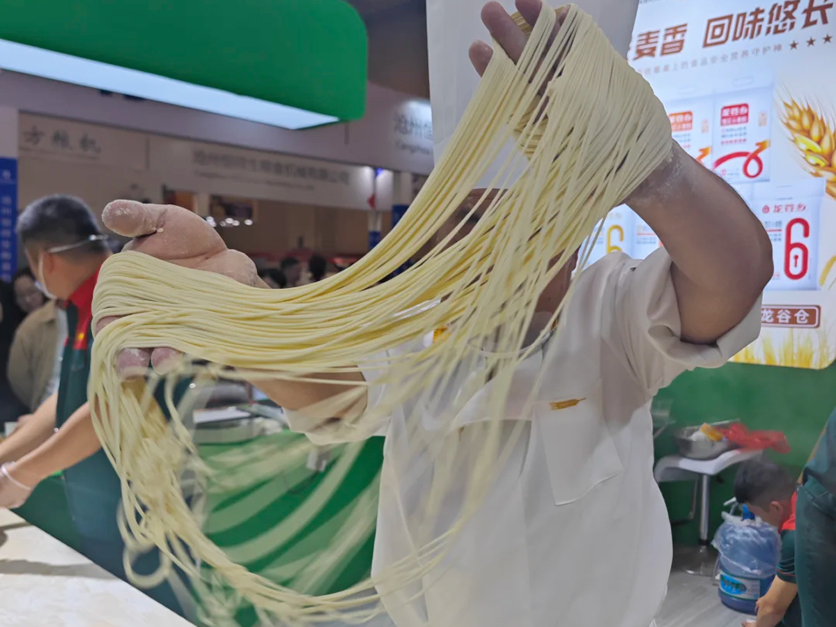 A chef stretching dough by hand to make pulled noodles